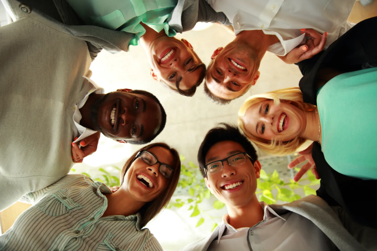 Happy Business People With Their Heads Together Representing Concept Of Friendship And Teamwork