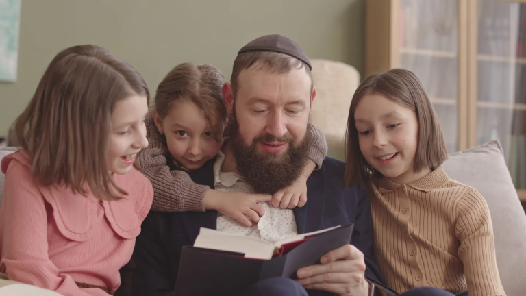 Jewish Father Reading Haggadah To His Three Little Daughters Celebrating Passover Seder At Home
